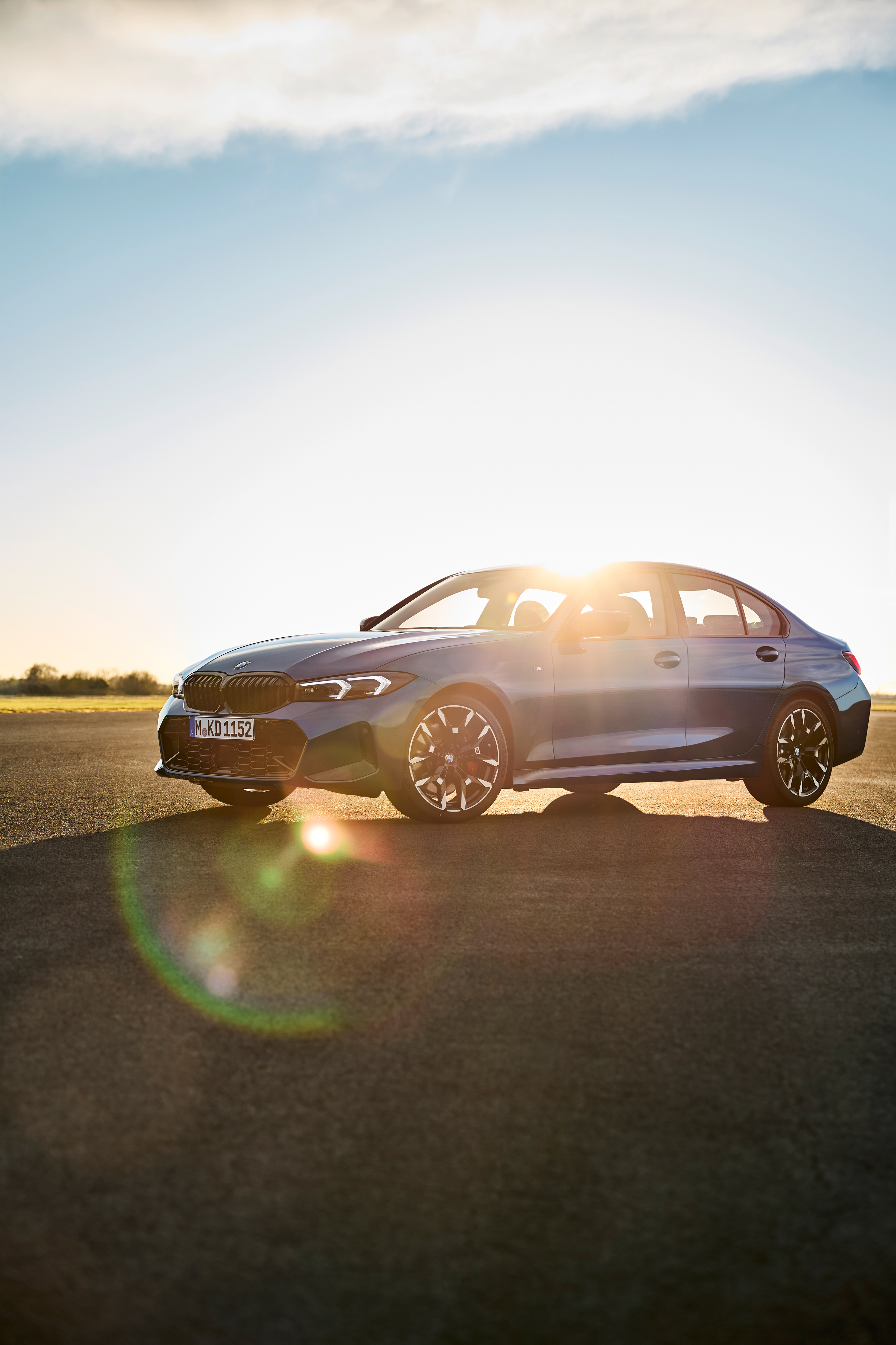 Blue BMW 3 Series Saloon photographed at sunset