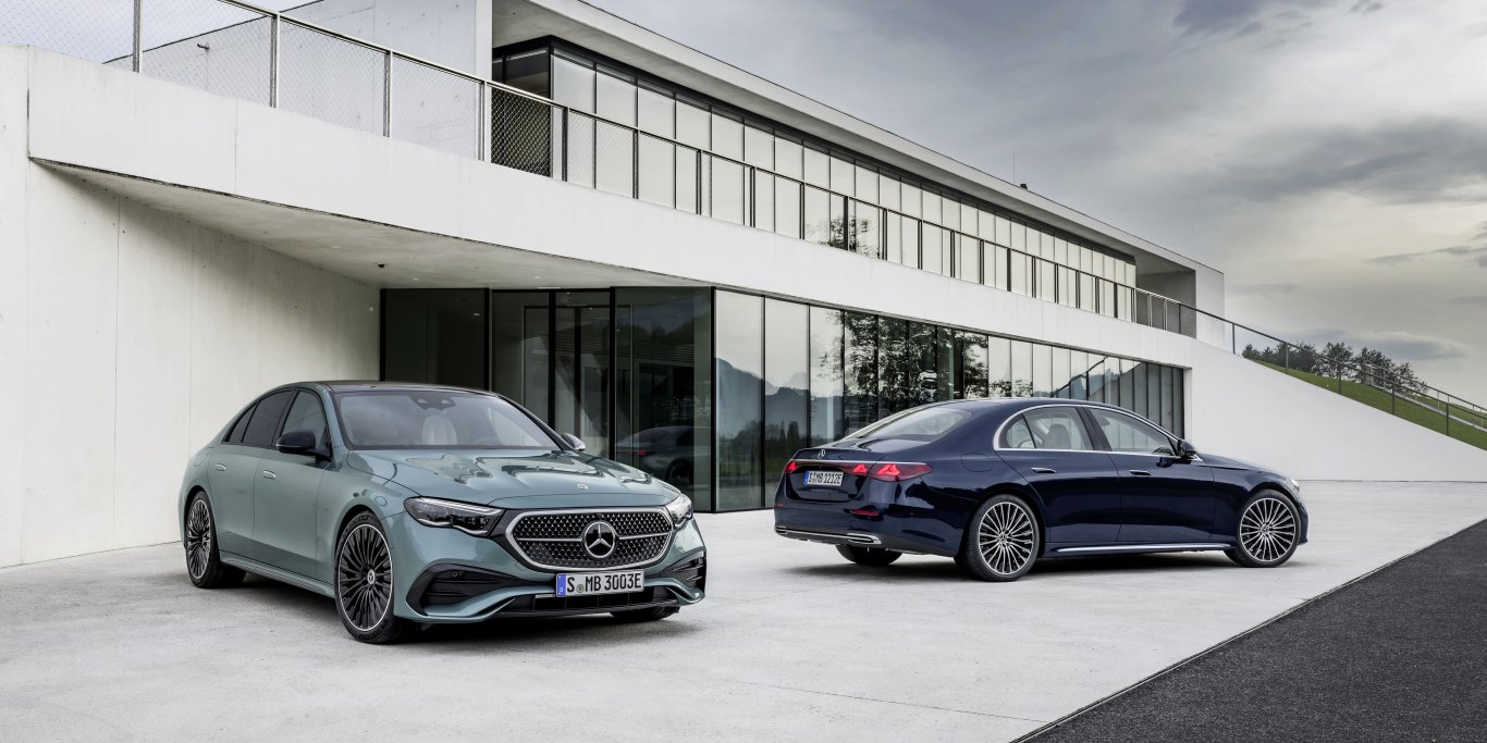 Two Mercedes-Benz E-Class saloons outside a modern building