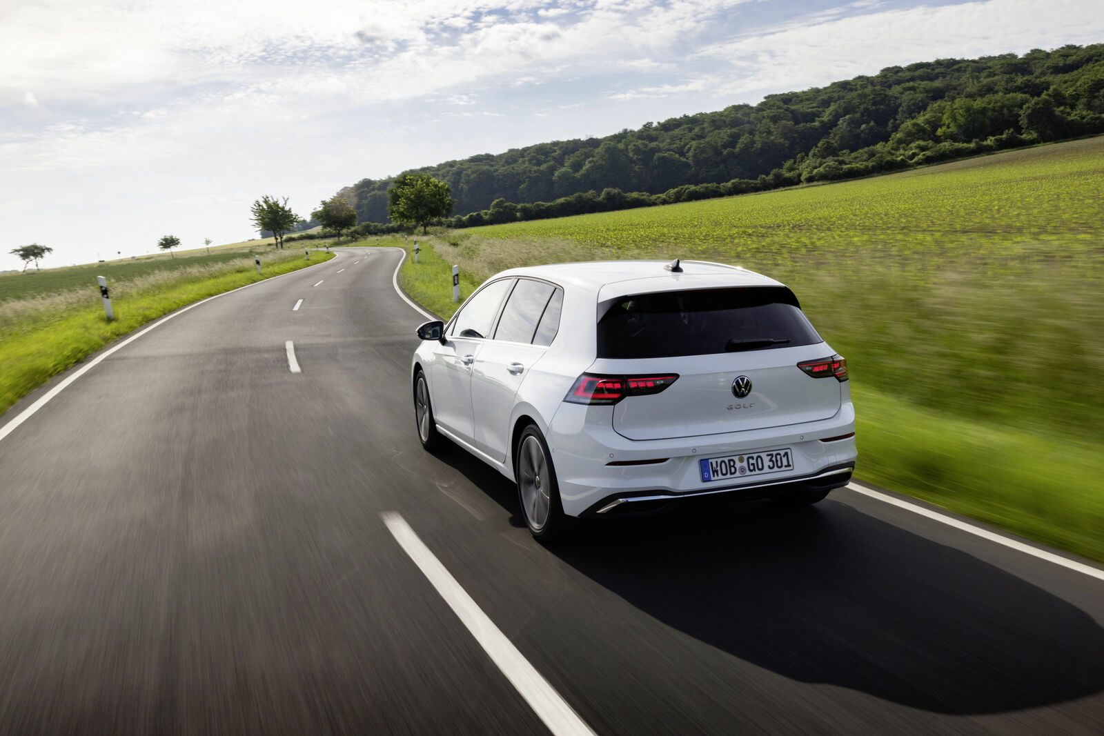 White Volkswagen Golf driving on a country road